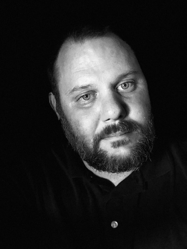 black and white photograph:  black background with a pop out of myself with a beard and crew cut hair.  My hair is brown, beard is redish/gray, and sea green/blue eyes.